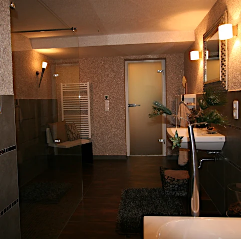 Modernes Bad in Braun-/Graut&ouml;nen, mit gro&szlig;en Fliesen und auf den oberen Wandfl&auml;chen Baumwollputz