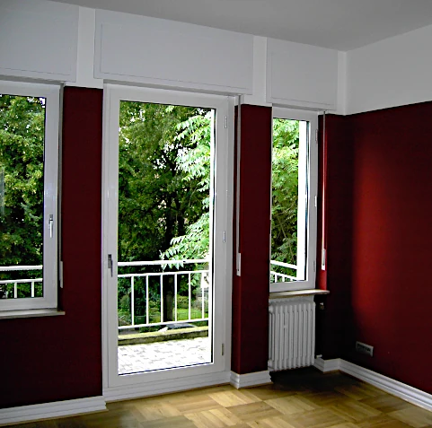 Wohnraum mit angelegten roten Tapeten und weißen Bereichen oben