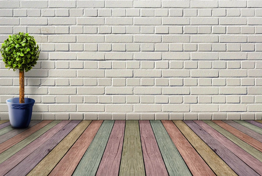 Steinwand mit farbigen Holzdielen im Vordergrund